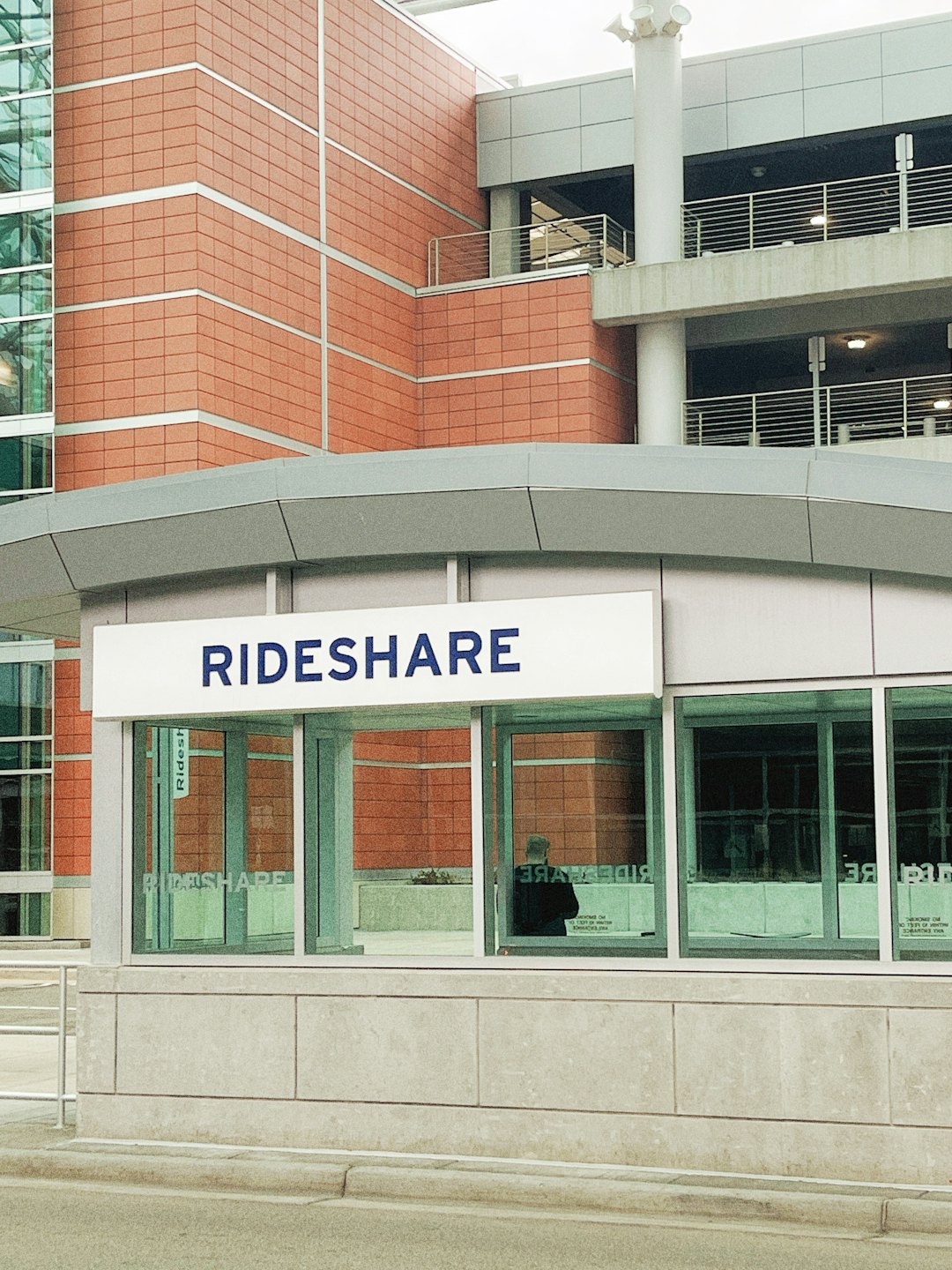 Modern rideshare waiting area with 'RIDESHARE' sign.